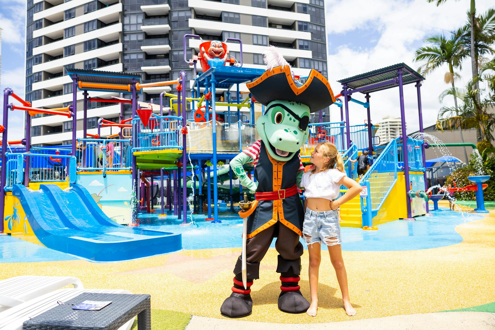 Resort mascot Captain posing with a guest in front of the expansive waterpark.