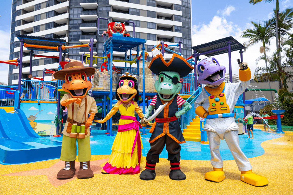 Four resort mascots named Dusty, Cleo, Captain, and Astro standing in front of a large waterpark.