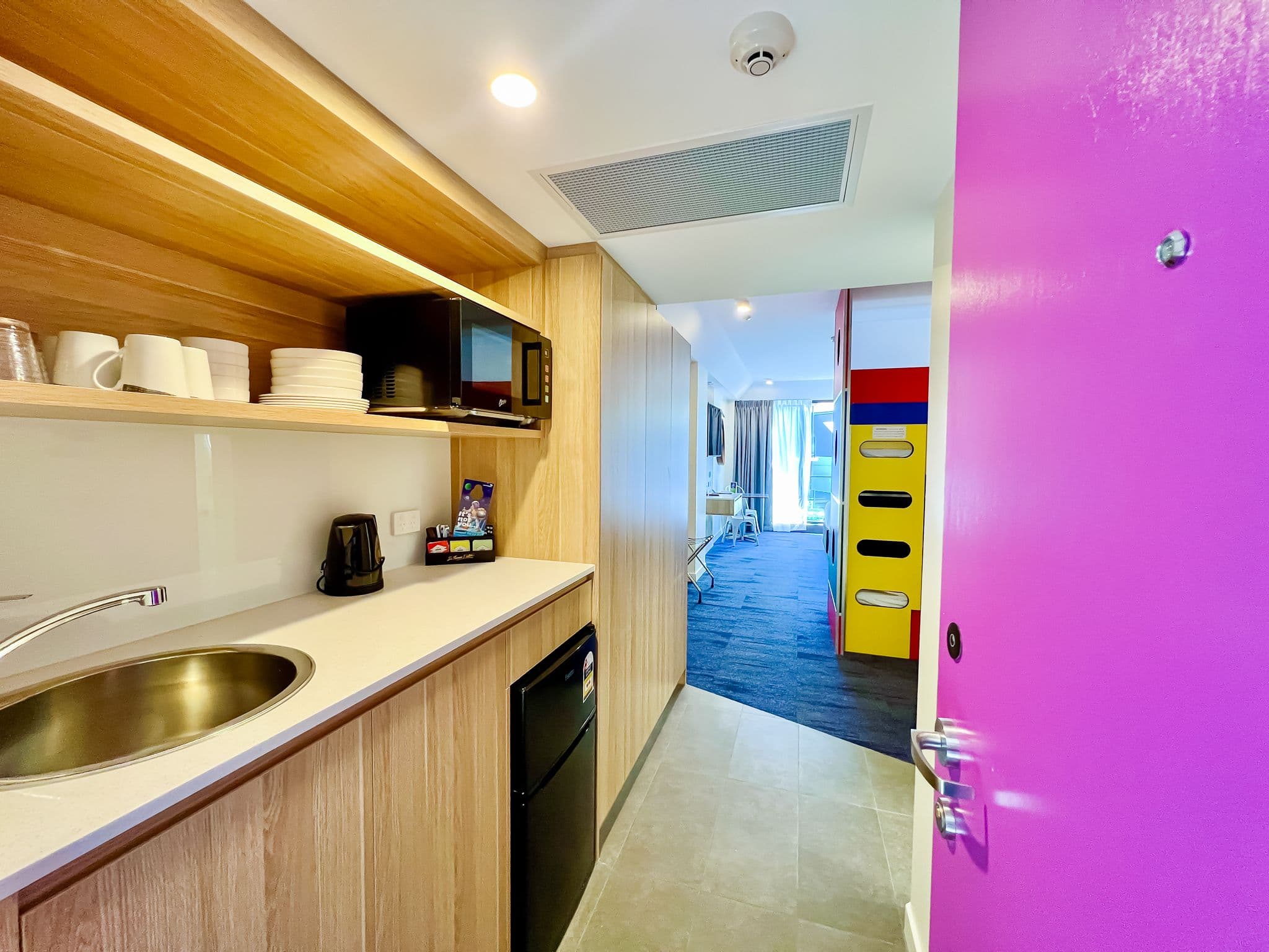 Small kitchenette with sink, microwave and basic crockery