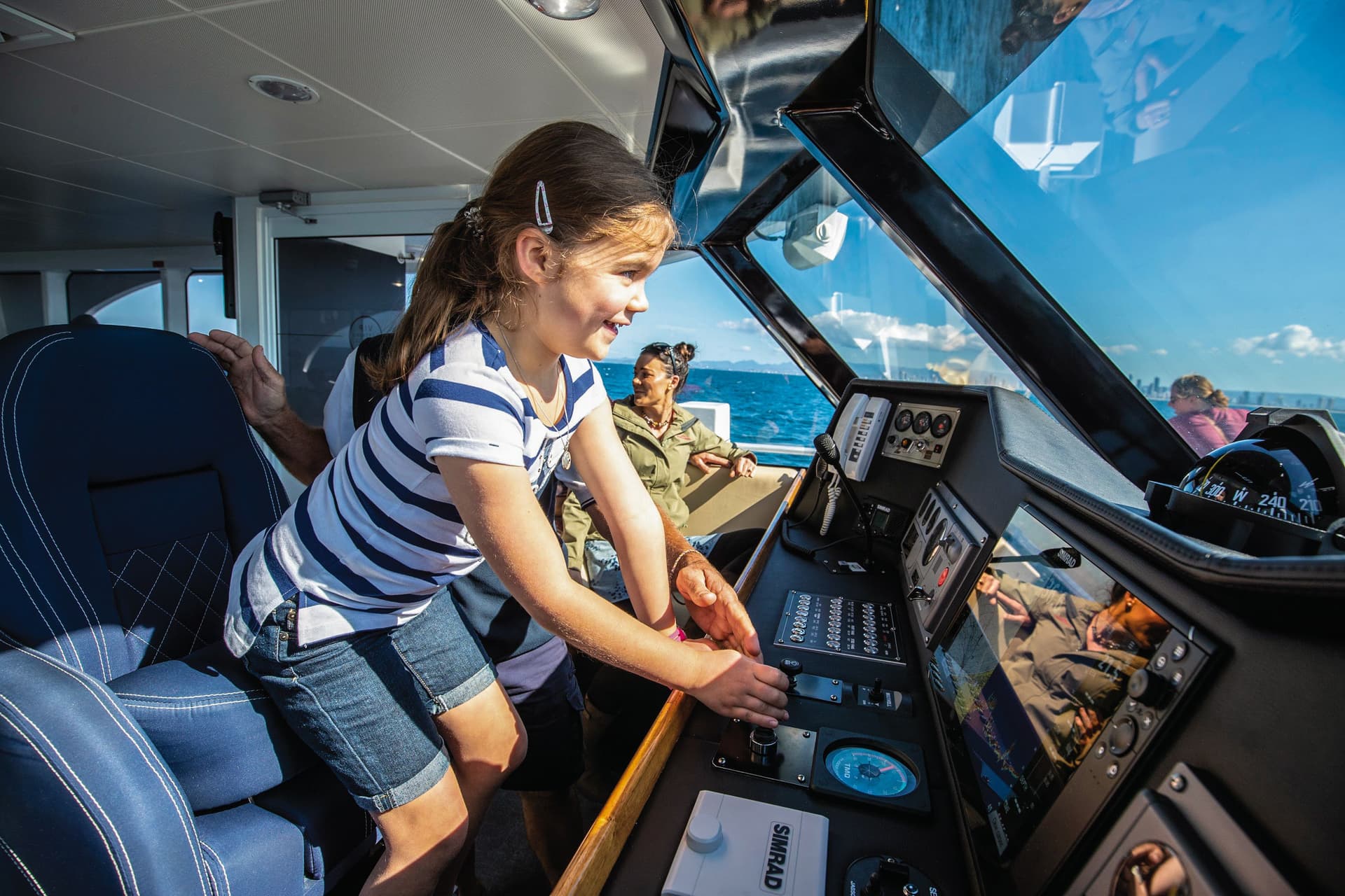 sea world cruises captains lounge with young girl driving the boat