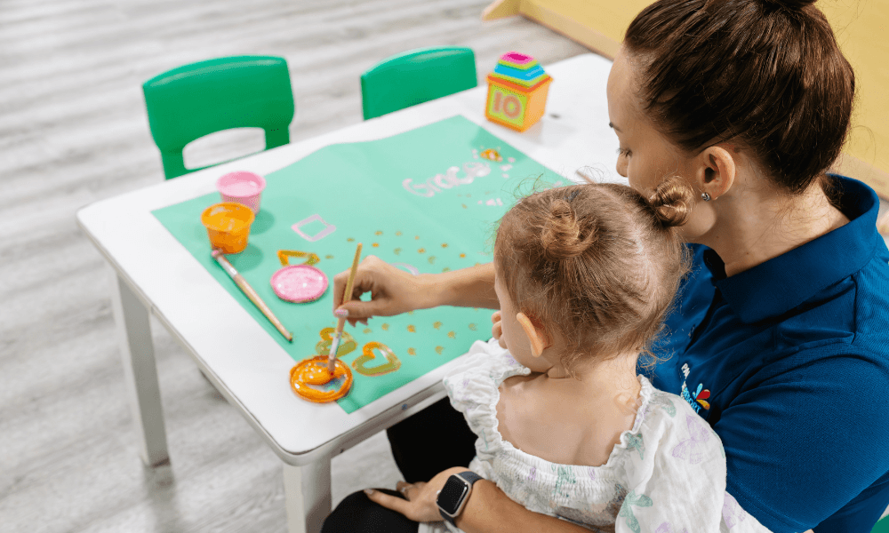 child care working painting with child